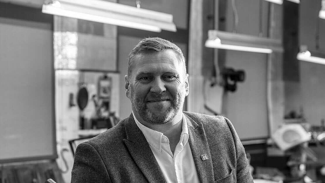 man in suit in front of shop