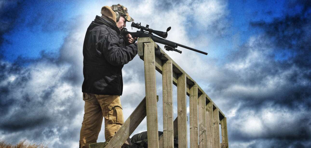 man aiming a rifle
