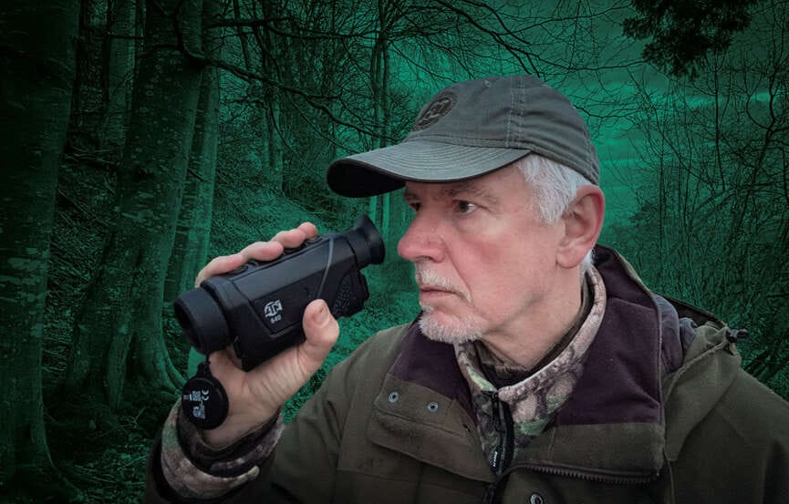 man using a riflescope in a wooded area